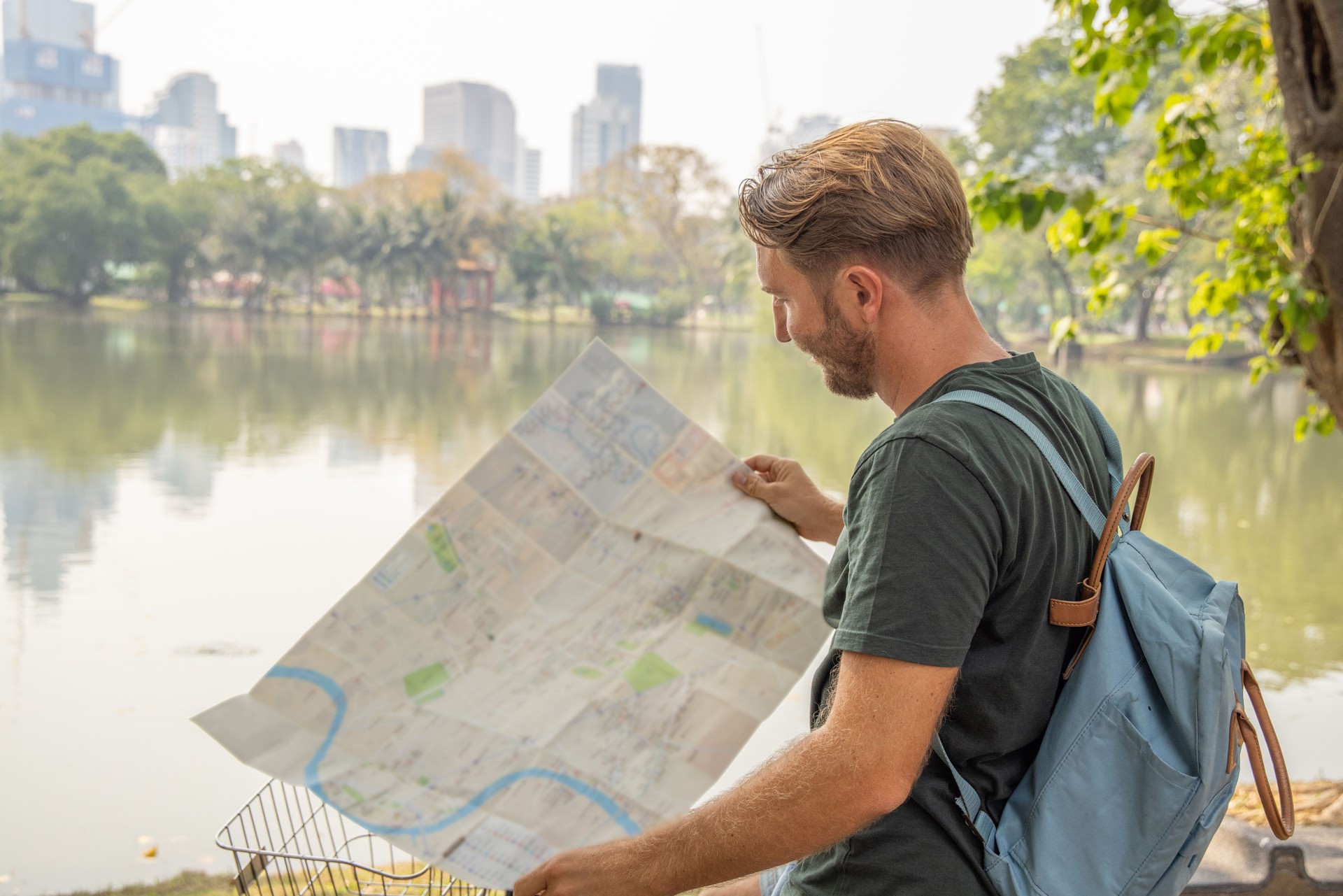 Young man exploring Asia with a bicycle, he looks at map