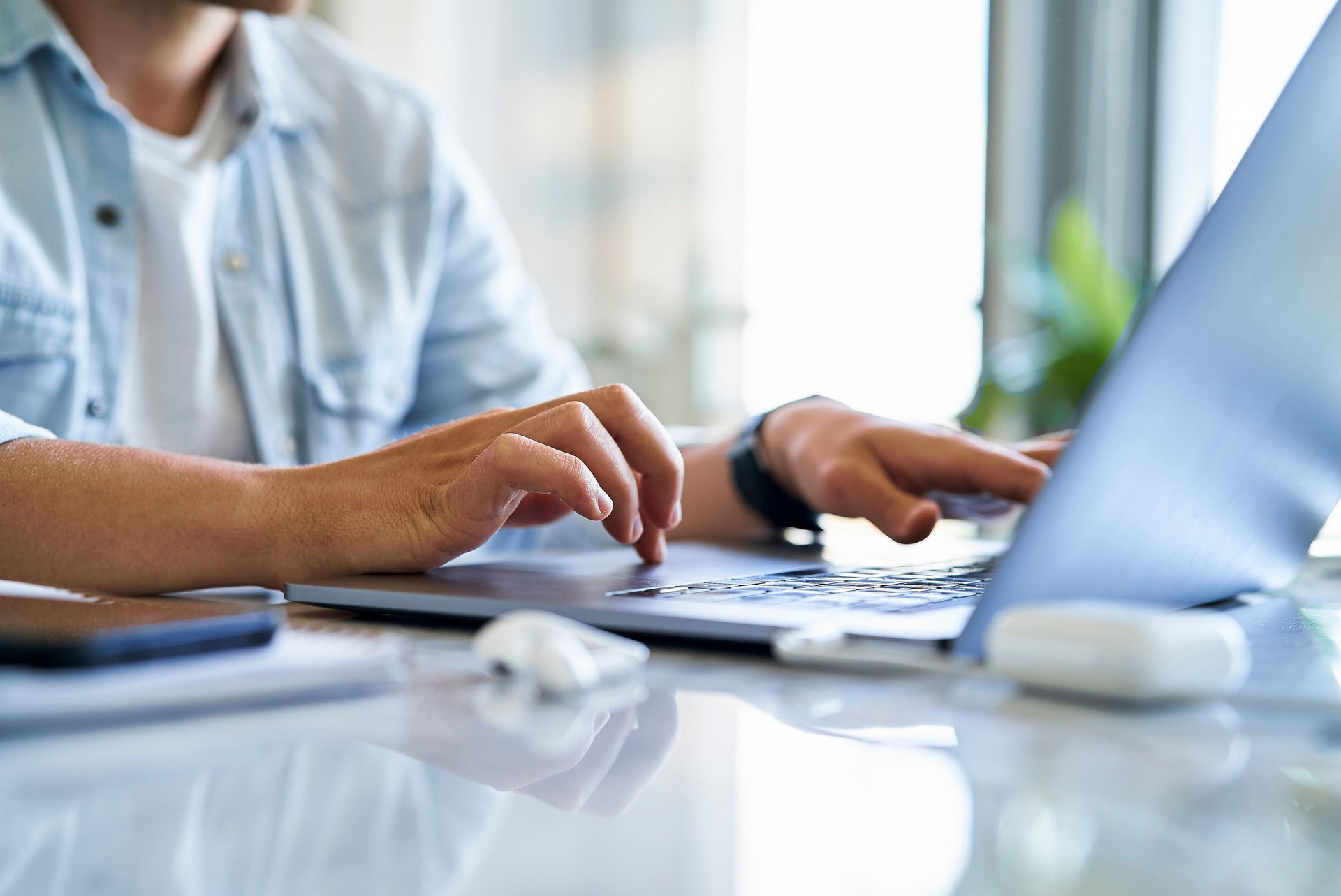 Mid section of male designer holding credit card while doing online shopping during daytime