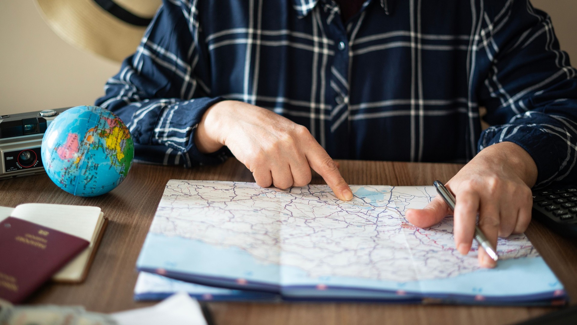 Close-up Woman planning vacation with world map